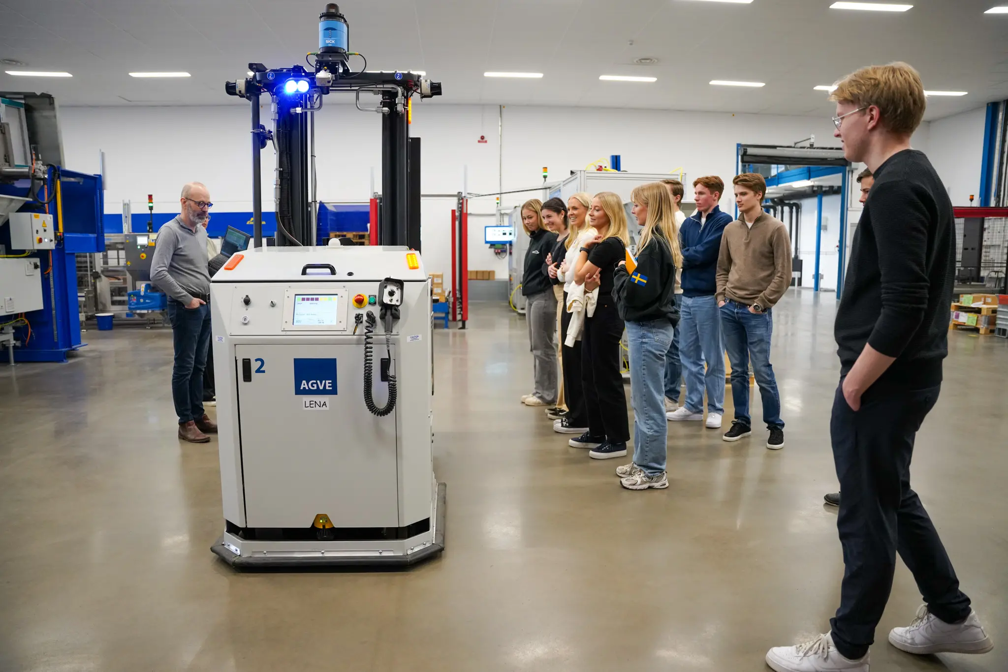 En grupp JTH-studenter står och kollar på en gaffeltruck