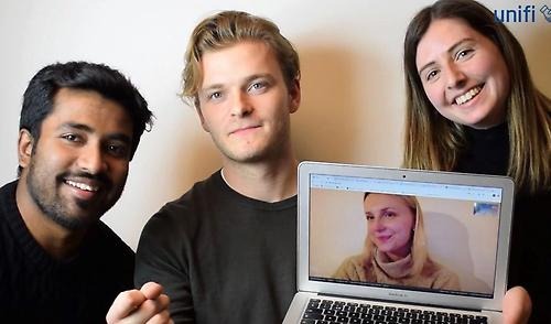 Group photo of team 4. Two men and two women, whereof one is shown on a computer. 