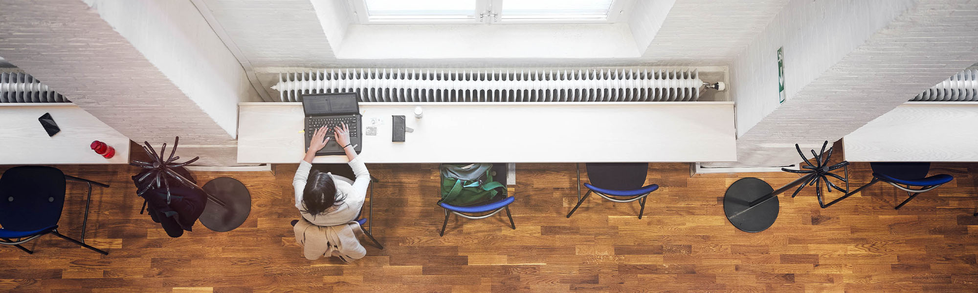 A lone student studying at a table seen from above.